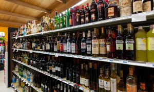 Various alcoholic beverages arranged nicely on supermarket shelves as an example of alcohol distribution.