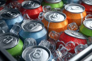 Ice-cold beverage cans surrounded by ice inside a cooler